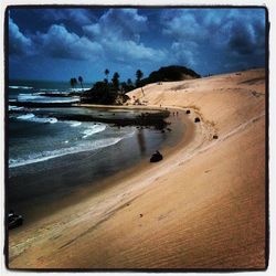 Scenic view of beach against cloudy sky