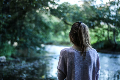 Rear view of woman standing in forest