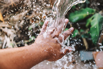 Midsection of man splashing water in park