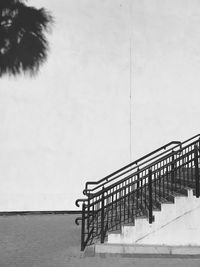 Staircase against wall against clear sky