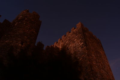 Low angle view of illuminated castle against sky at night