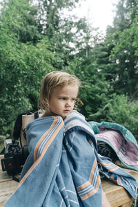 Boy looking at camera against trees