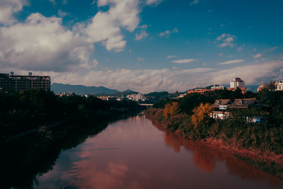 River amidst buildings in city against sky