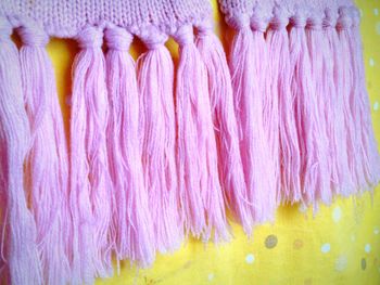 Close-up of knitted pink scarf on fabric