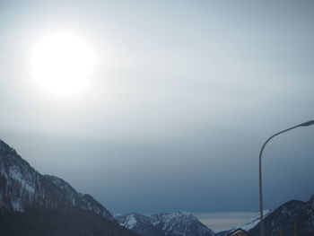 Low angle view of snow covered mountains against sky