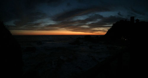 Scenic view of sea against dramatic sky during sunset