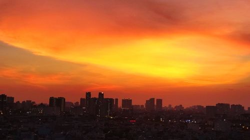 Silhouette buildings against sky during sunset