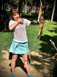 Full length of woman holding bow 