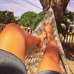 Low section of woman relaxing on hammock