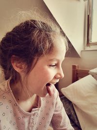 Close-up of girl sticking out tongue at home