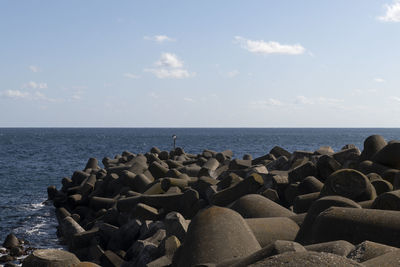 Stack of stones on beach against sky