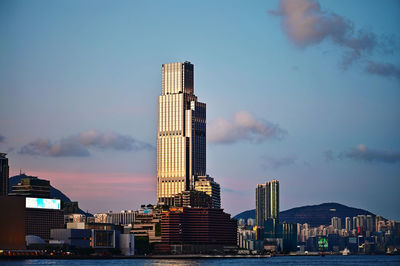 Modern buildings in city against cloudy sky