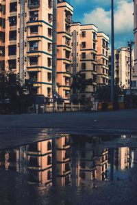 Buildings by river against sky in city