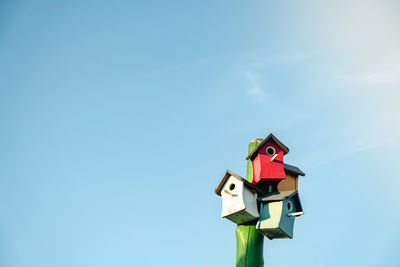 Wooden small bird houses and birdhouses against the blue sky. real estate and affordable housing