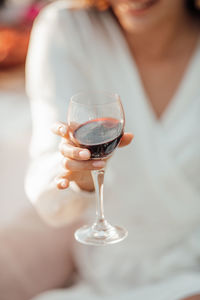 Midsection of woman holding wineglass