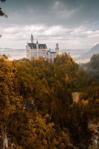 Building amidst trees against sky