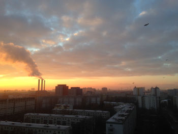 View of cityscape against cloudy sky