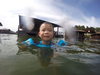 Boy in water against sky