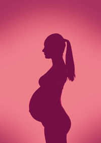 Side view of silhouette woman standing against red background