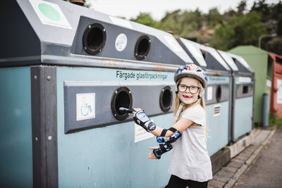 Girl putting rubbish into recycling bin