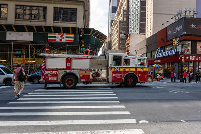 Vehicles crossing road against buildings in city