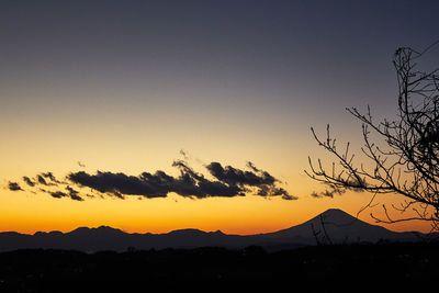 Scenic view of silhouette mountains against clear sky at sunset