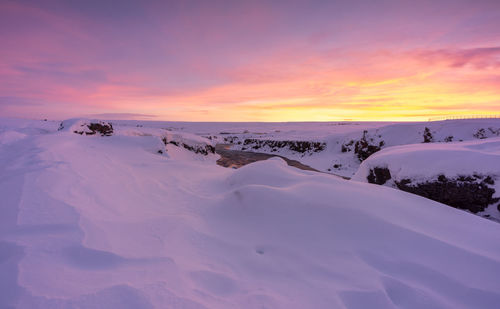 Scenic view of snow covered landscape against sky during sunset