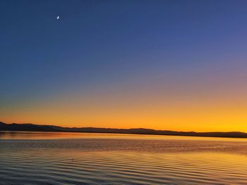 Scenic view of beach against clear sky during sunset