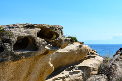 Rocks on beach against clear sky