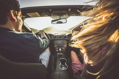 Rear view of man and woman in car