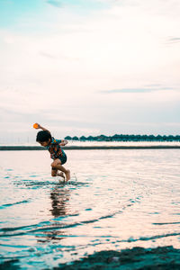 Man riding in sea against sky