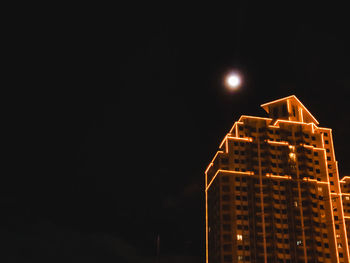 Illuminated building against sky at night