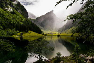 Scenic view of lake by mountains against sky