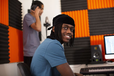 Smiling music composer sitting in recording studio
