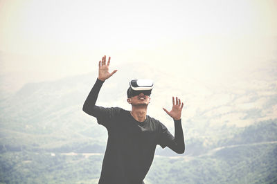 Man wearing virtual reality simulator on mountain