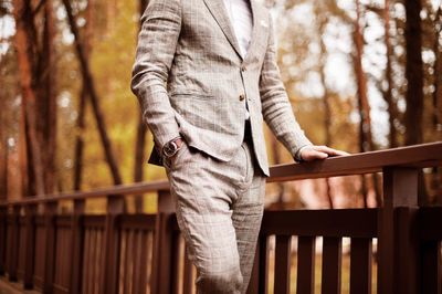 Midsection of well-dressed man standing in park