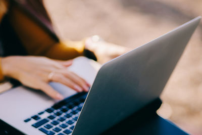 Midsection of woman using laptop