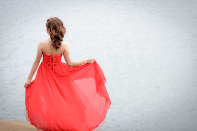 Rear view of woman standing against sea