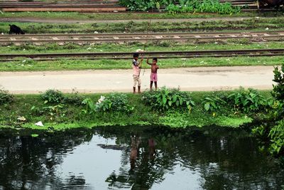 Reflection of friends standing on puddle