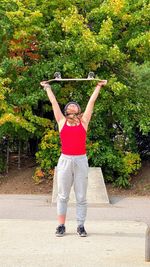 Full length portrait of woman standing against plants