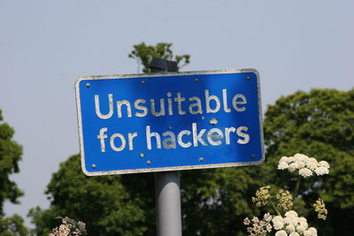 Close-up of information sign against plants