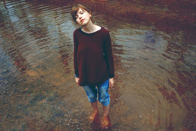 Full length of woman with eyes closed standing in lake