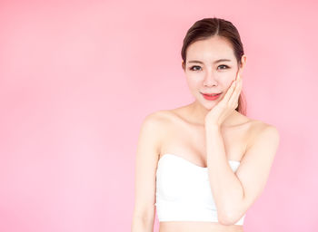 Portrait of a beautiful young woman over pink background