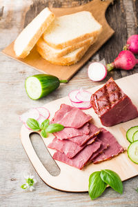 Fresh sliced marbled beef pastrami and vegetables on a cutting board. american delicacy