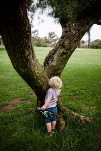 Full length of woman on tree trunk