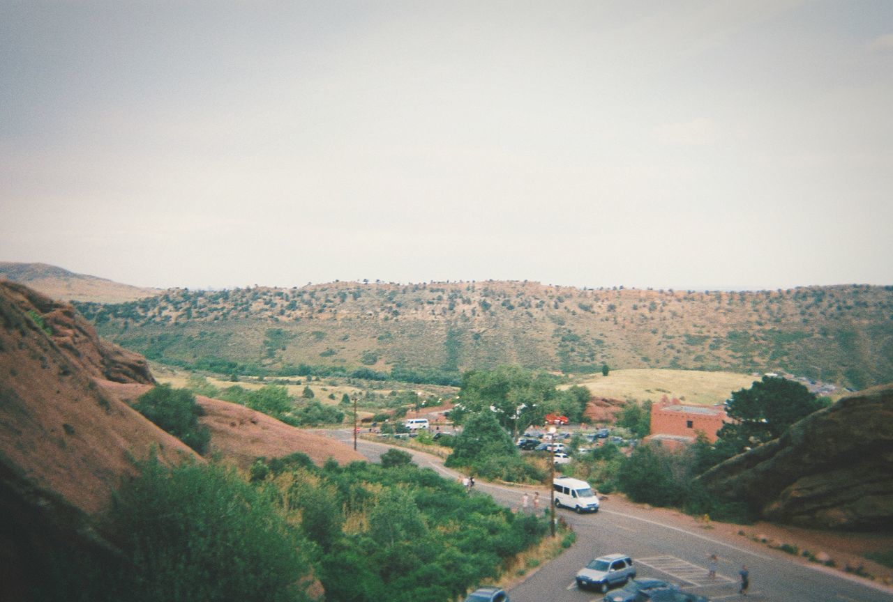 HIGH ANGLE VIEW OF ROAD AMIDST TREES AND LANDSCAPE AGAINST SKY