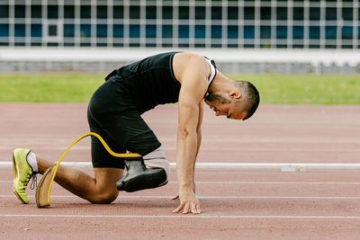 Low section of man exercising on field