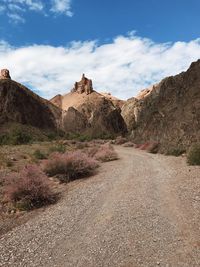 Road leading towards mountains against sky