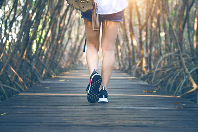 Low section of woman running on boardwalk