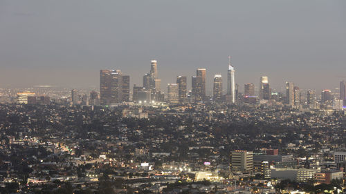 Illuminated buildings in city against sky